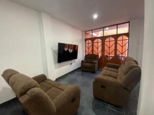 卡哈马卡Casa Hospedaje Cajamarca的客厅配有2张沙发和1台平面电视
