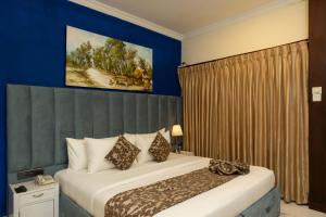 康提咖啡香气酒店的一间卧室设有一张蓝色墙壁的大床