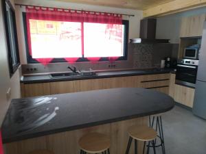 瓦卢瓦尔Chalet des Lys - tout confort - 12 personnes的厨房配有黑色台面和窗户