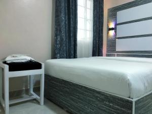 KisiiMt. Everest Hotel的卧室配有白色的床和窗户。