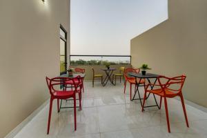 亚喀巴Three Palms Suites的一间设有红色椅子和桌子的用餐室以及窗户