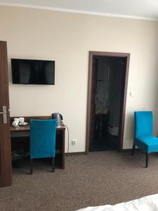 西维德尼察Świdnica Kolonia noclegi的酒店客房配有书桌和2把蓝色椅子