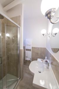 佩鲁贾福尔图纳酒店的带淋浴和盥洗盆的白色浴室
