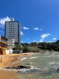 瓜拉派瑞Apartamento Guarapari pé na areia com Wi-Fi e Garagem的享有海滩美景,拥有建筑背景