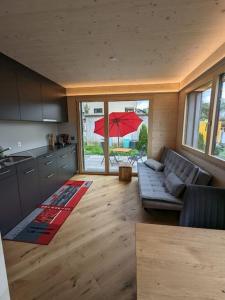 施伦贝格TinyHouse - (D)ein Ferienhaus的带沙发和遮阳伞的客厅