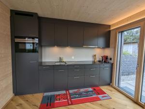 施伦贝格TinyHouse - (D)ein Ferienhaus的一间厨房,配有黑色橱柜和大窗户