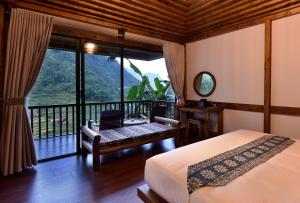 萨帕Maison de Lao Chai的一间卧室设有一张床和一个阳台