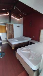 巴尔Cabañas Palos Locos的红色墙壁客房的两张床