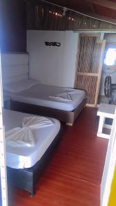 巴尔Cabañas Palos Locos的两张床铺位于一个房间,铺有木地板