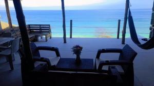 巴尔Cabañas Palos Locos的海滩上花瓶边的桌椅