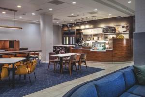 比尔里卡Courtyard by Marriott Boston Billerica Bedford的一间带桌椅和柜台的餐厅