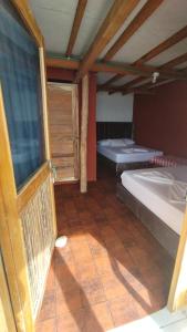 巴尔Cabañas Palos Locos的客房设有两张床和窗户。