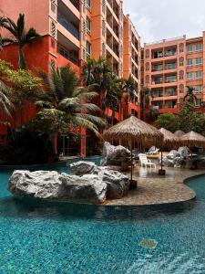 乔木提恩海滩Seven Seas Resort Pattaya的度假村内带椅子和遮阳伞的游泳池