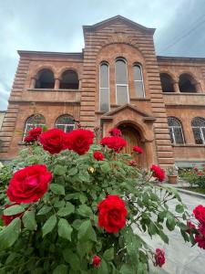 VagharshapatNajaryan's Family Guest House的一群红玫瑰在一座建筑前