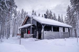普哈圣山Charming log house - Lumous B - Pyhätunturi - Finland的森林雪地中的小木屋