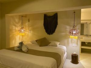 普拉亚卡门Isabella Boutique Hotel的一间卧室配有一张带两个灯的床