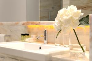 波尔图波尔图世界遗产佩斯塔纳复古酒店的浴室水槽花瓶上的白色花朵