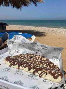 艾因苏赫纳Spacious Penthouse Chalet at Telal Sokhna的沙滩上的一张桌子上的一个甜甜圈