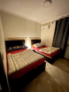艾因苏赫纳Spacious Penthouse Chalet at Telal Sokhna的卧室配有两张床,墙上有灯