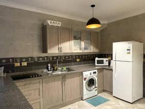 艾因苏赫纳Spacious Penthouse Chalet at Telal Sokhna的厨房配有白色冰箱和洗碗机。