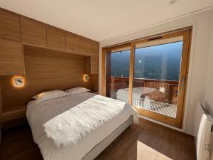 美贝尔Newly renovated 7-9pers Luxury Chalet in Meribel Centre 85m2 3BR 3BA with stunning Mountain View的一间卧室设有一张床和一个大窗户