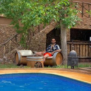 布马伦维勒查鲁利亚德旅馆的坐在游泳池旁椅子上的男人