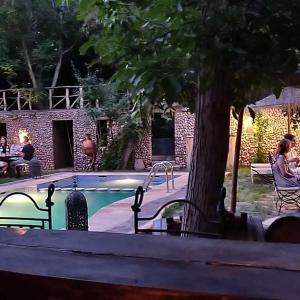 布马伦维勒查鲁利亚德旅馆的一座带两个长椅和一棵树的游泳池