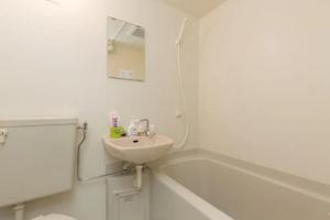 大阪幸运经济型酒店的白色的浴室设有水槽和浴缸。
