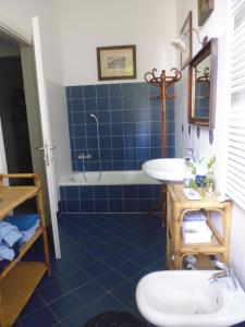 科莫伊尔普拉塔诺公寓的蓝色瓷砖浴室设有浴缸和水槽