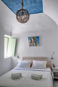 卡马利Mythos Traditional Stonehouse的一间卧室配有一张带吊灯的大床