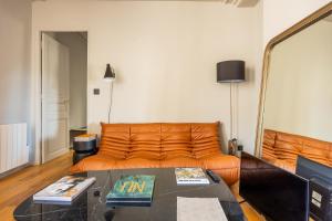 巴黎Bail Mobilite Luxe Le Marais的客厅里一张橙色的沙发,配有桌子