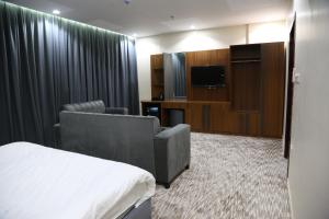 麦地那فندق انسام طيبة للضيافة的酒店的客房 - 带一张床、椅子和电视