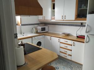 格拉纳达Casa en Purchil的小厨房配有白色橱柜和微波炉