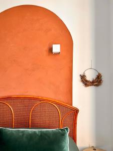米卢斯Aux Arcades Mulhouse Hyper Centre的一间卧室配有橙色床头板和绿色枕头