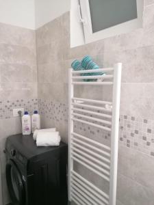 阿拉西奥Dolce Far Niente的一间带洗衣机和架子毛巾的浴室