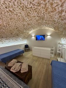 锡拉库扎菊苣度假屋的一间配有沙发的房间和墙上的电视