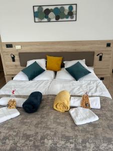 佐洛卡罗斯Dani Wellness Apartman的一张大床,配有三张毯子和枕头