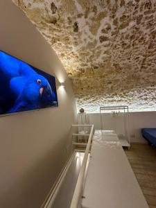 锡拉库扎菊苣度假屋的一间墙上挂有电视的房间