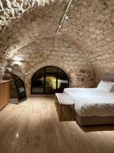 兹奇隆亚科夫Hagafen Boutique Suites的卧室配有一张石墙床