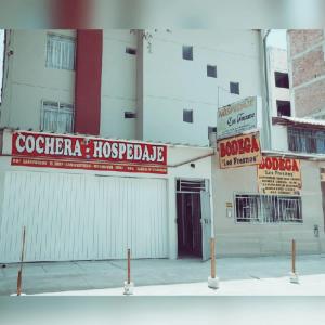 皮乌拉Hospedaje Residencial Los Fresnos - Miraflores Piura的白色的建筑,旁边有红色的标志