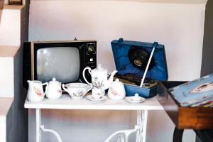 圣米格尔-杜斯米拉格里斯Pousada Chalés do Toque的一张桌子,配有电视和一些茶壶和茶杯