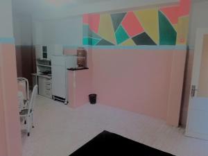 维多利亚Hostel Leonardo 10 Estrelas的厨房的墙上装饰着色彩缤纷的绘画作品