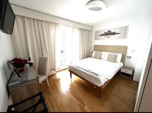 Longostagno维塞夫天然酒店的一间卧室配有一张床和一张书桌及电视