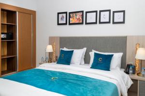 达赫拉Hotel Golden Sunset Dakhla的一间卧室配有一张带蓝色枕头的大床