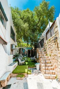 萨法德Maim Haim Tzfat - Boutique Suites Prime location Old City Tzfat的石头房子,带秋千的院子
