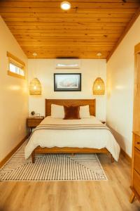 帝王鲑The Lodge at 58* North的一间卧室设有一张床和木制天花板