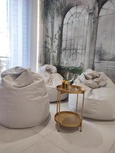 科内利亚诺AL PONTE design apartment的一间设有两个白色豆袋和桌子的房间