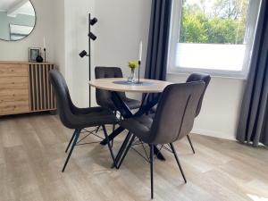 代特莫尔德QT Apartments Detmold的餐桌、四把椅子和镜子