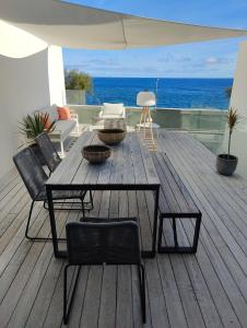 圣罗克Barrocas Villas Azores的一个带桌椅的木制甲板和大海