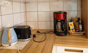 罗瓦涅米Capsule Hotel Ibedcity的厨房柜台配有咖啡壶和搅拌机